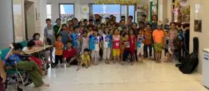 Groupe d'enfants et d'adultes à l'orphelinat Tê Phan à Ho Chi Minh Ville, réunis pour un moment chaleureux